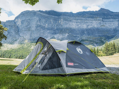 Opgezette Coleman Darwin 3+ tent op een camping, ideaal voor kampeerders en festivalgangers.