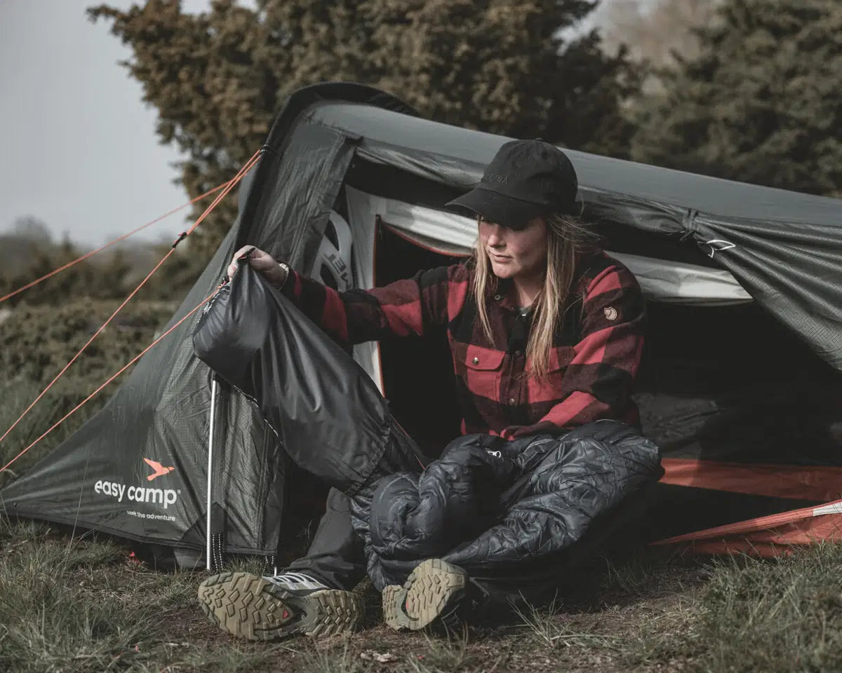 Easy Camp Sarek 1 Tent opgezet in een bosrijke omgeving, ideaal voor solo kampeeravonturen.