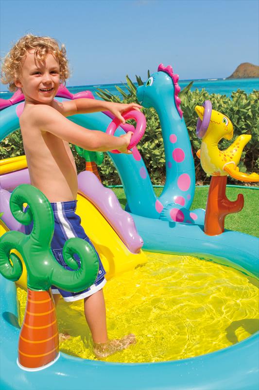 Opgeblazen Intex speelzwembad met glijbaan en vrolijke dino-accenten in de tuin