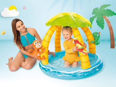 Baby speelt in het Intex Tropical Island babyzwembad met vrolijk tropisch design