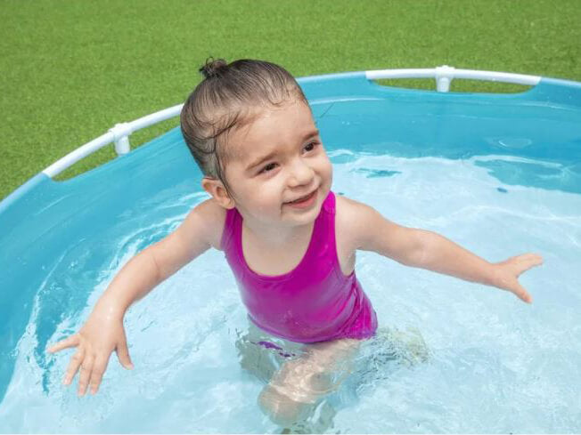  Blije kinderen spelen en spetteren in een Bestway My First Frame Pool zwembad.