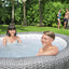  Lay-Z-Spa Honolulu AirJet in een tuin, ideaal voor ontspanning met warm water en bubbels.