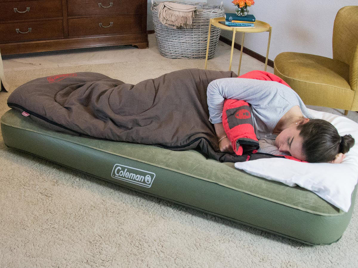 Een persoon die ontspannen slaapt op een comfortabel luchtbed tijdens een kampeertrip.